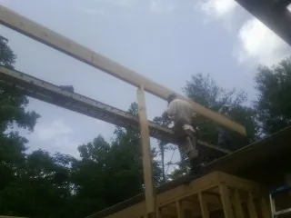 Carpenter setting a ridge beam over a new addition frame — Ice Dam Removal by Roofing Brothers in Elmwood