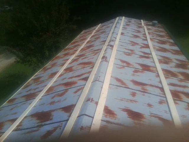 Rusted metal roof panels with new wood purlins before replacement — Storm Damage Roof Repair in Elmwood by Roofing Brothers